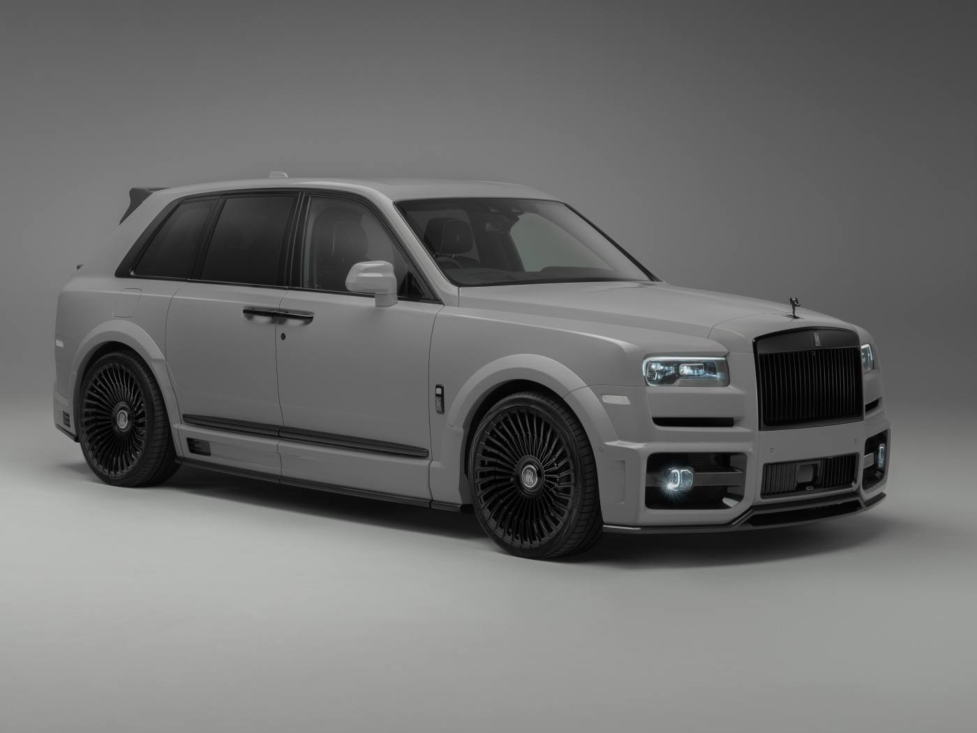 Автомобиль Rolls-Royce Cullinan на сером фоне