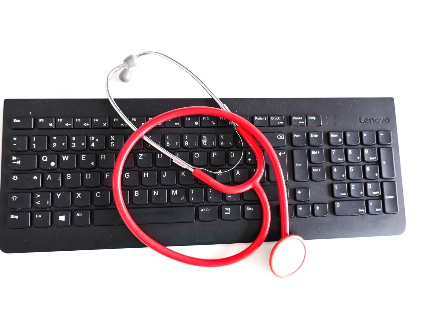 Черная клавиатура с фонендоскопом на белом фоне