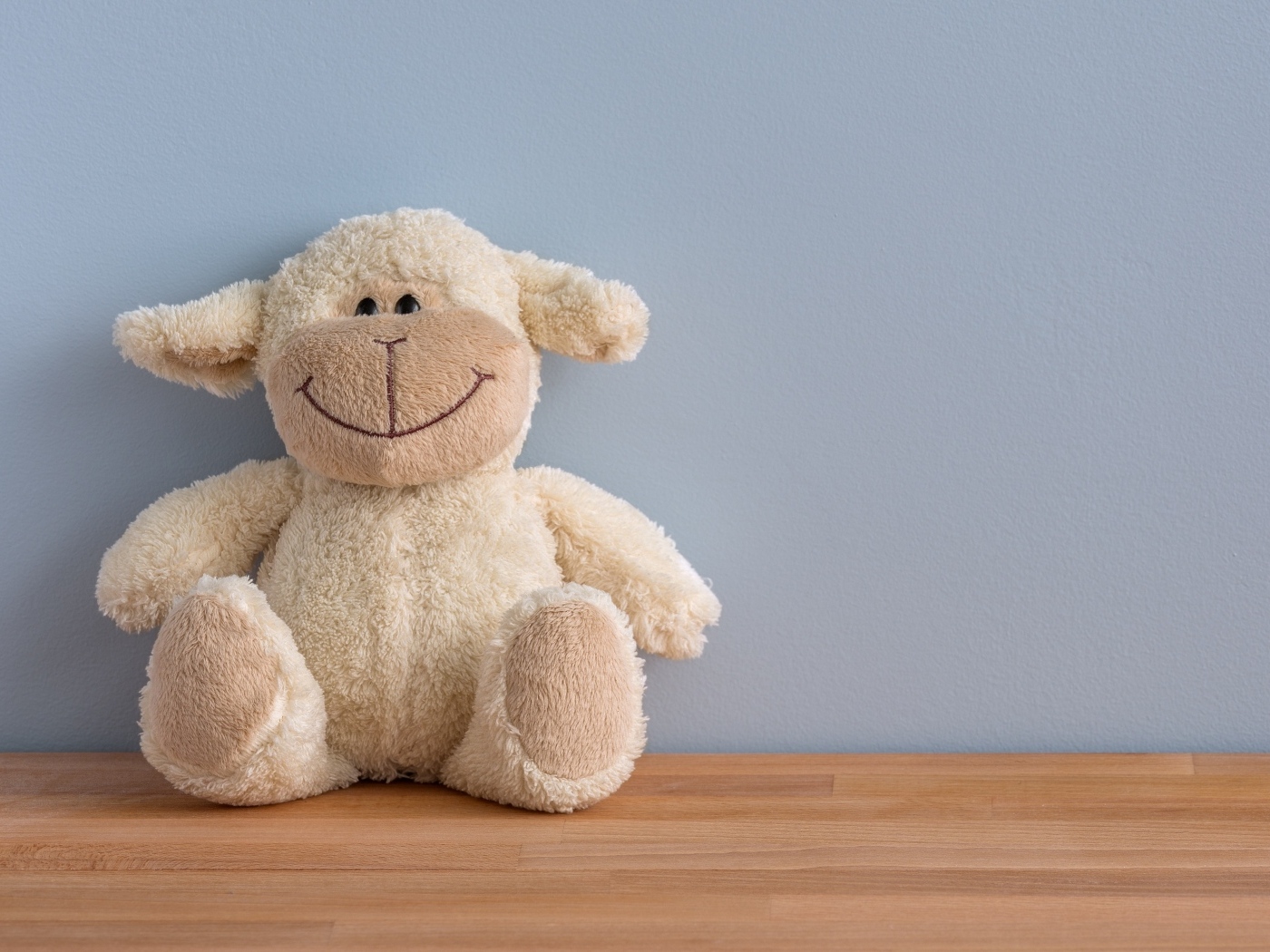 Детская игрушка на полу у серой стены