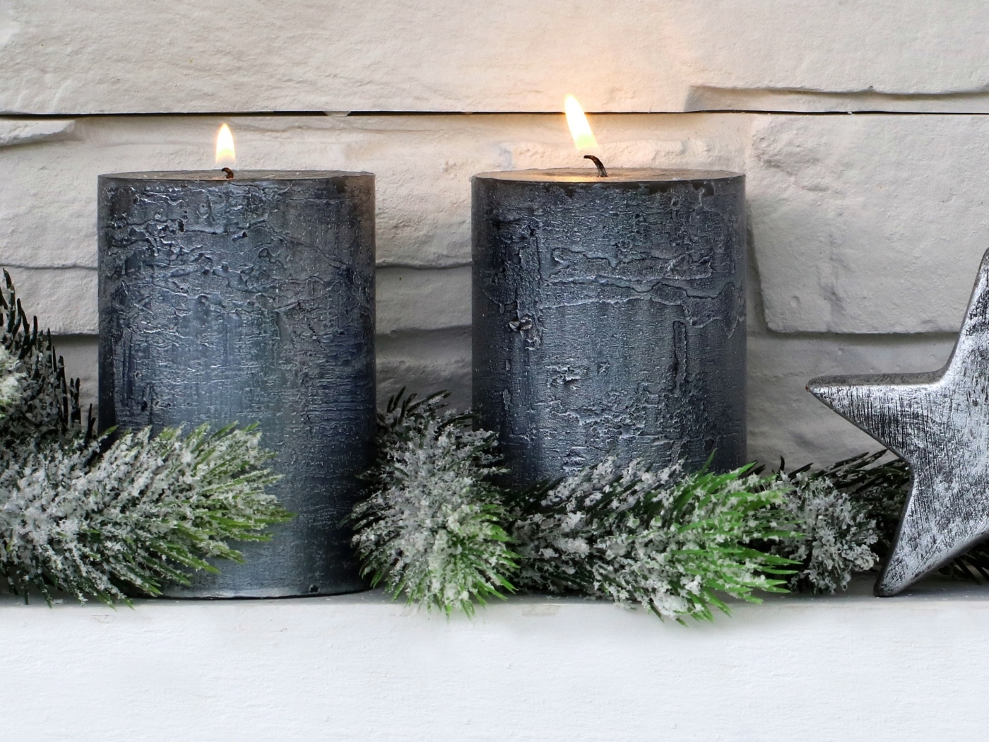 Две большие зажженные свечи у стены