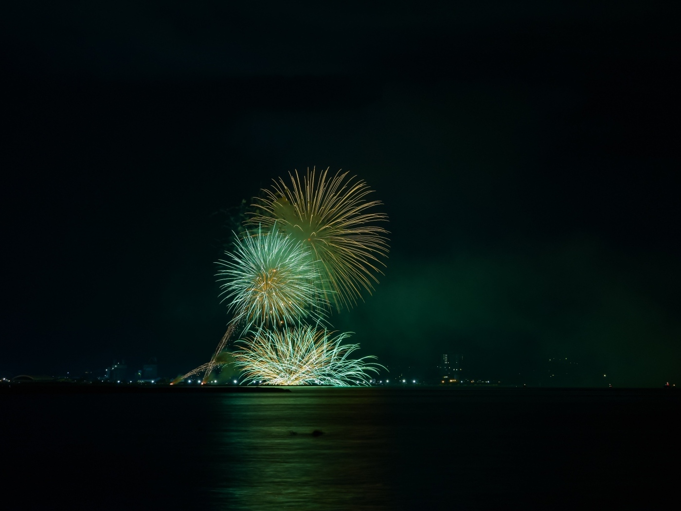 Вид с воды на красивые искры салюта