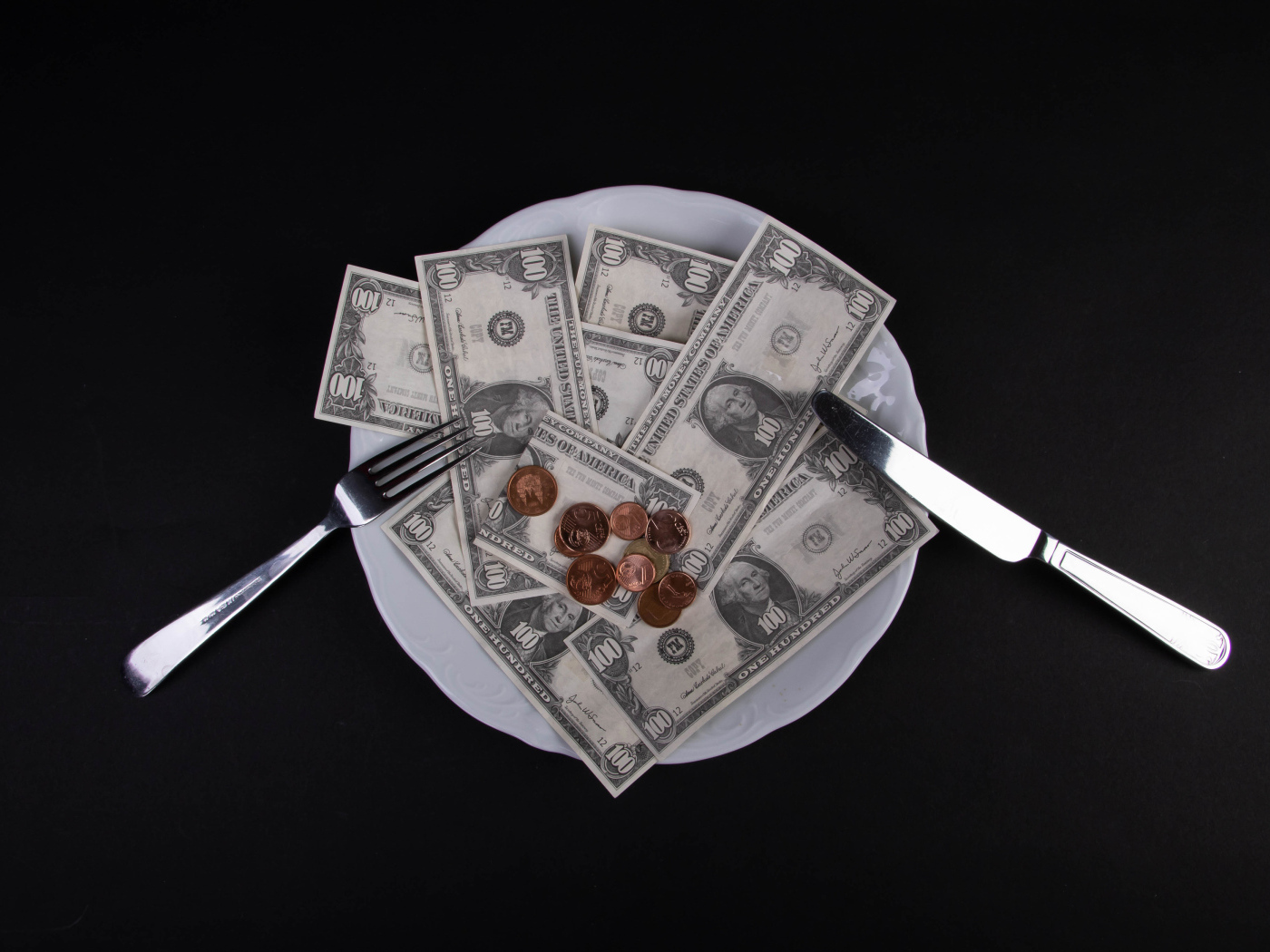 Тарелка с долларами на черном фоне