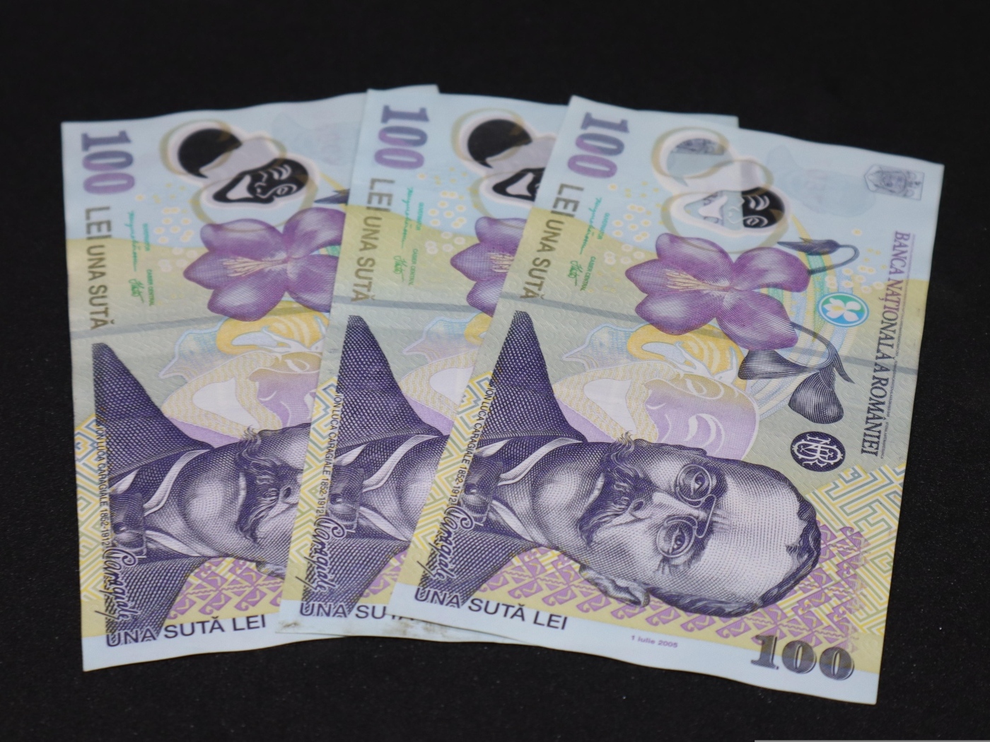 Три купюры на черном фоне