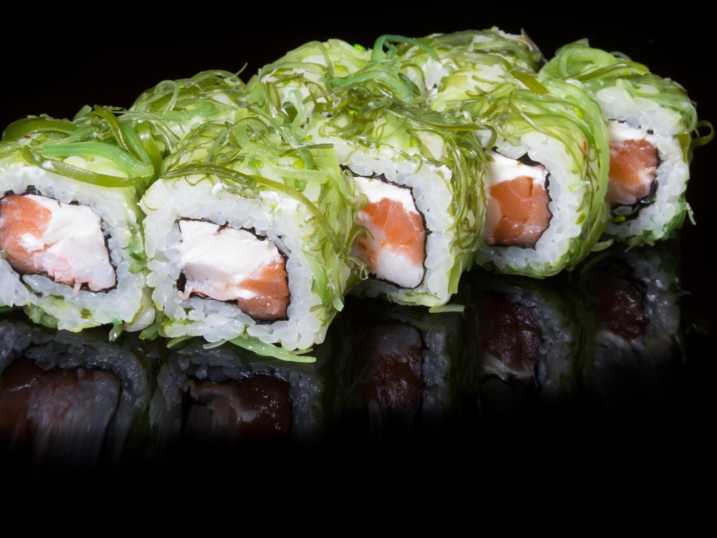 Аппетитные роллы с рыбой на черном фоне