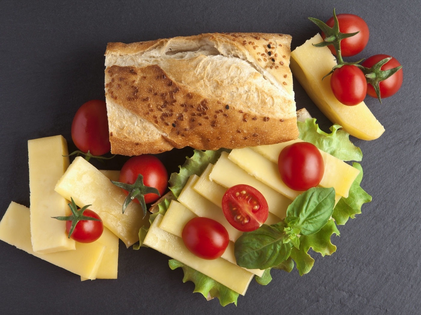 Сыр с батоном и помидорами на столе