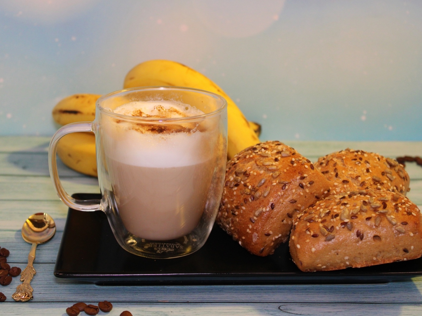 Чашка какао на столе с булочками и бананами