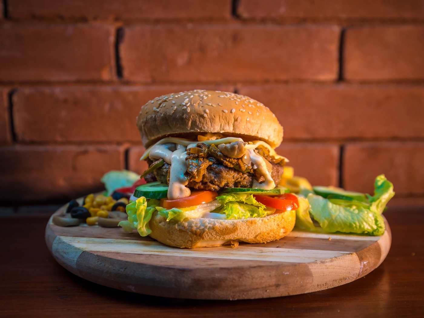 Большой аппетитный гамбургер на фоне стены