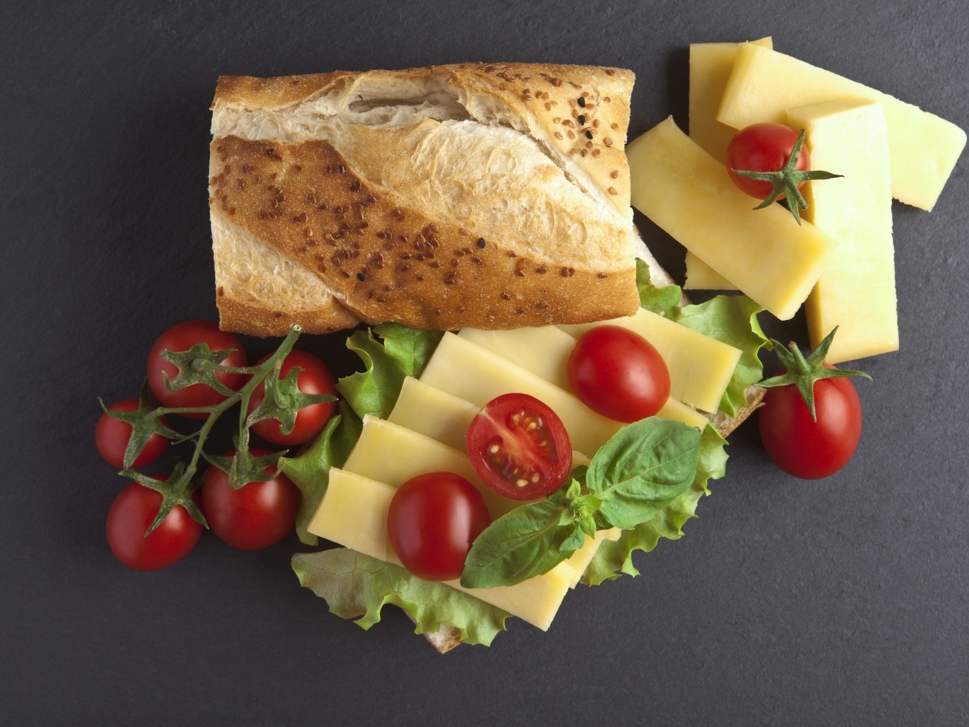 Батон с сыром и помидорами на сером фоне