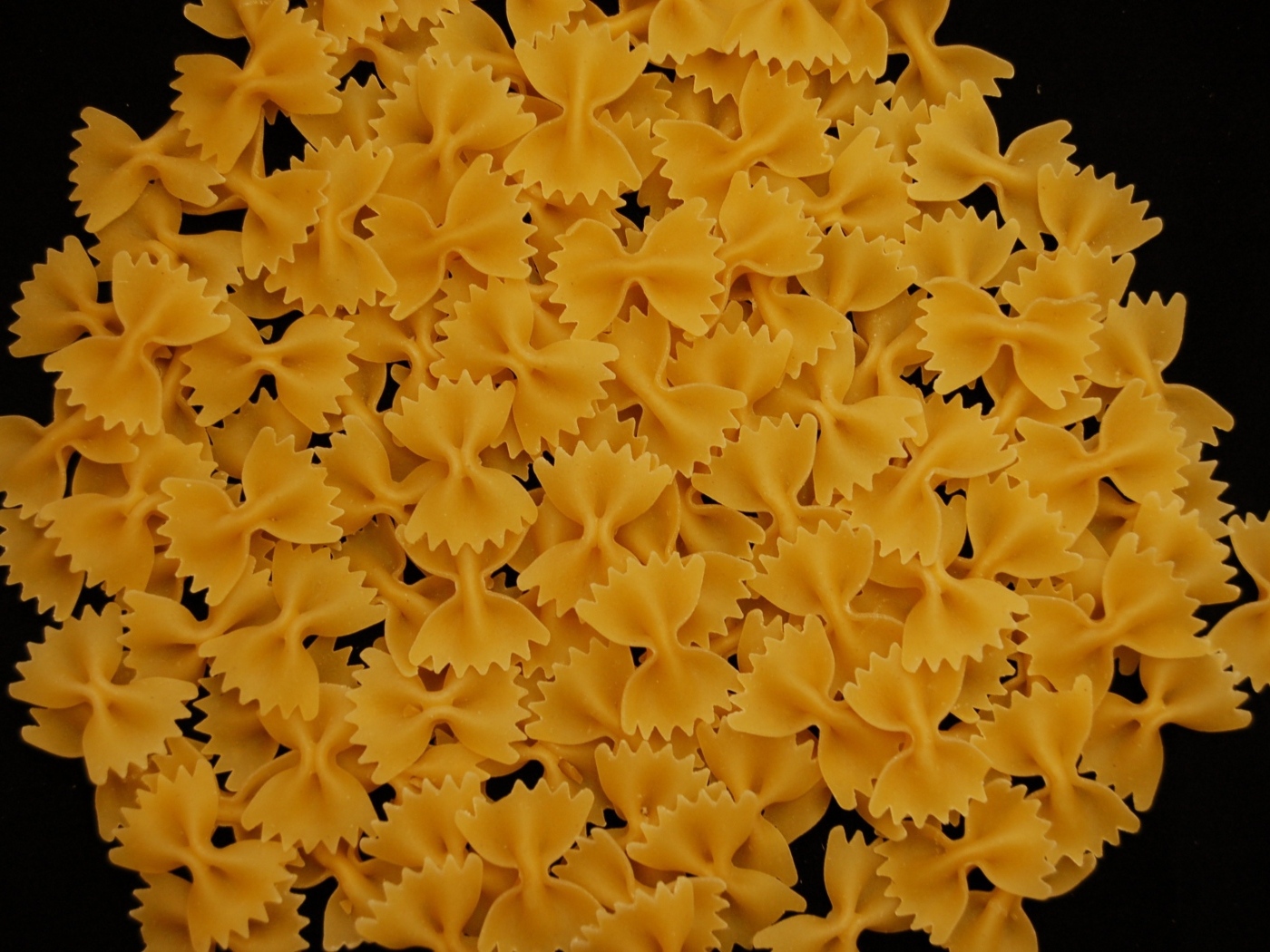 Макароны в форме бантиков на черном фоне