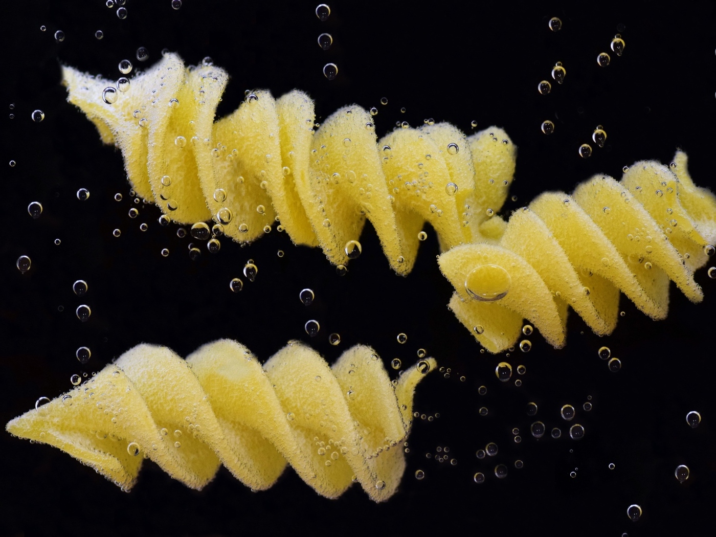 Макароны в воде на черном фоне