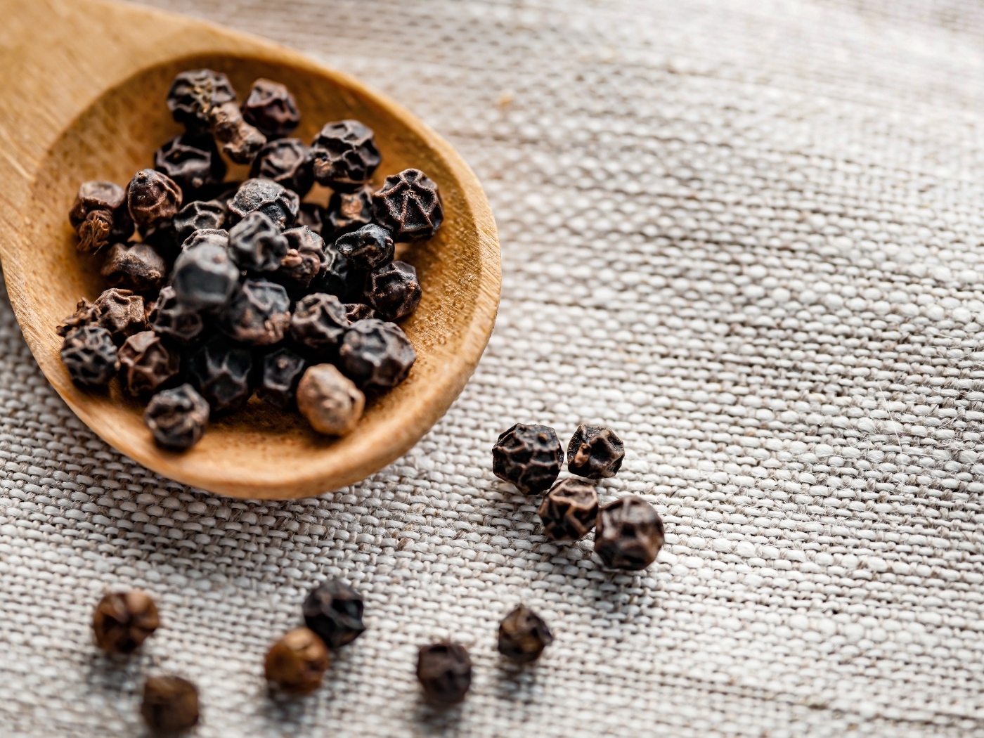 Перец горошком на деревянной ложке