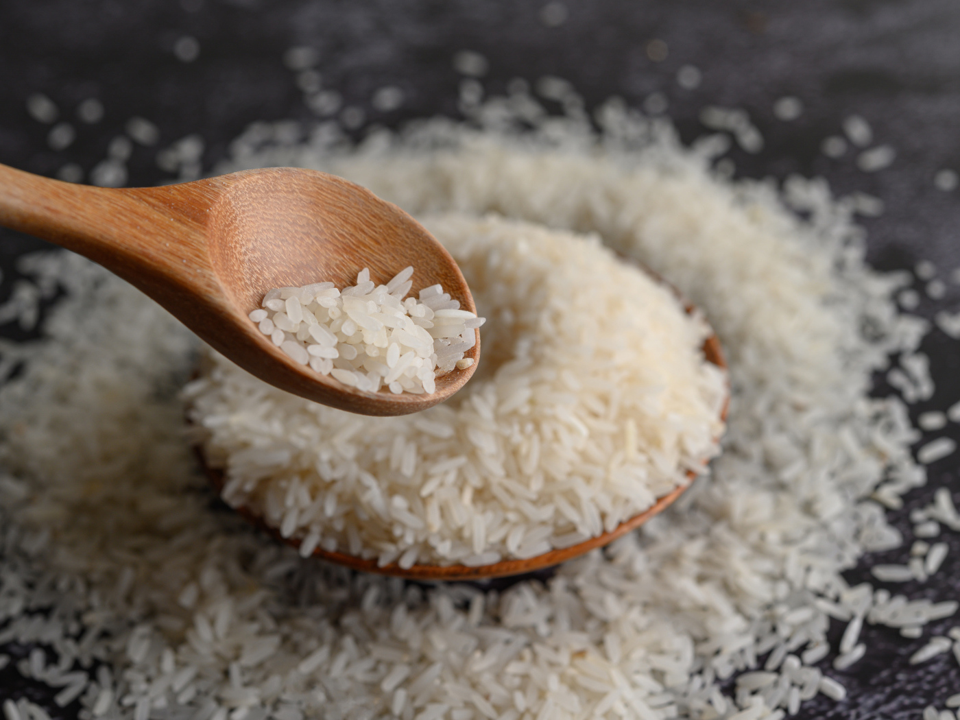 Белый рис на столе с деревянной ложкой 