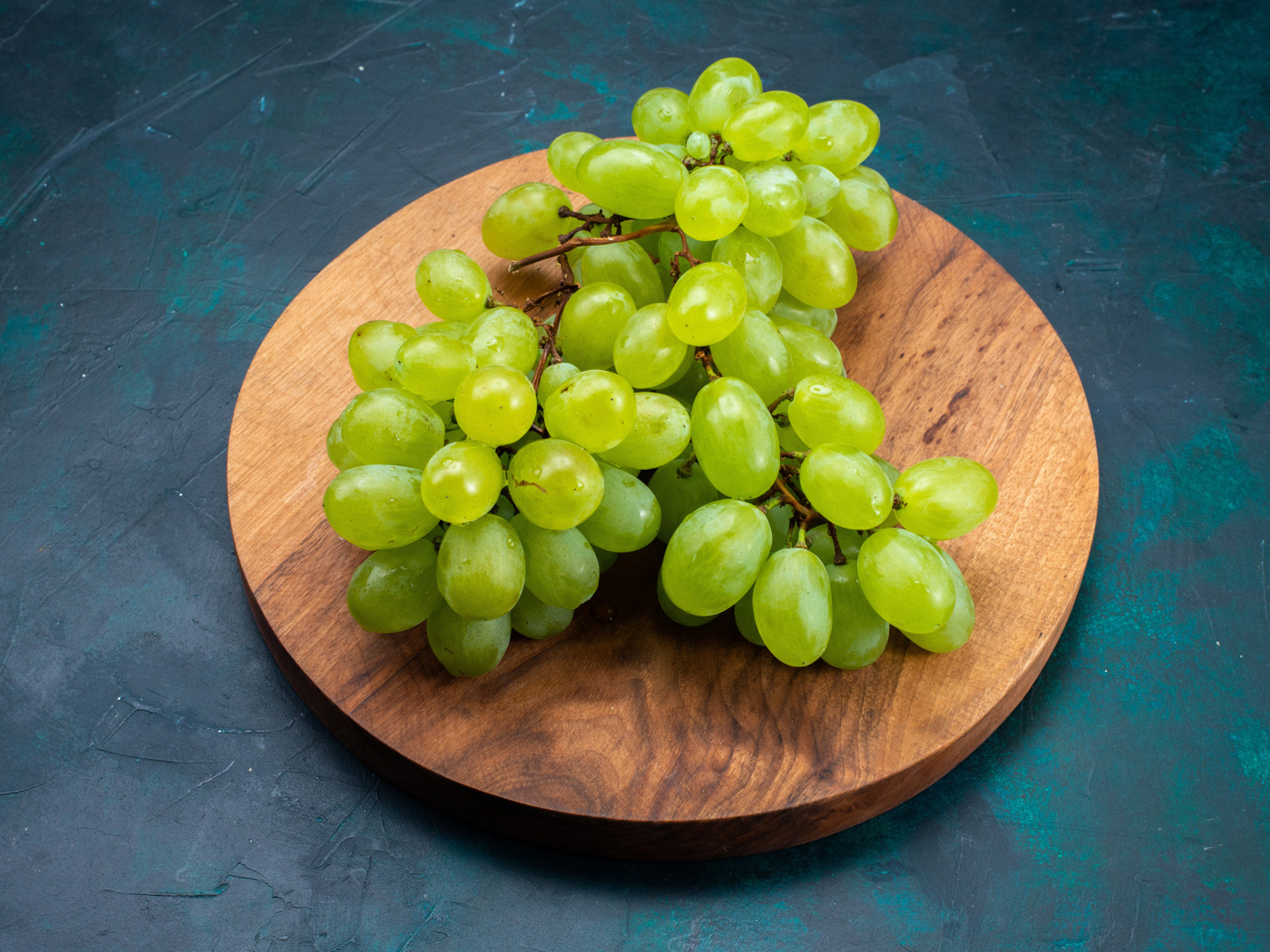 Зеленый виноград на деревянной доске