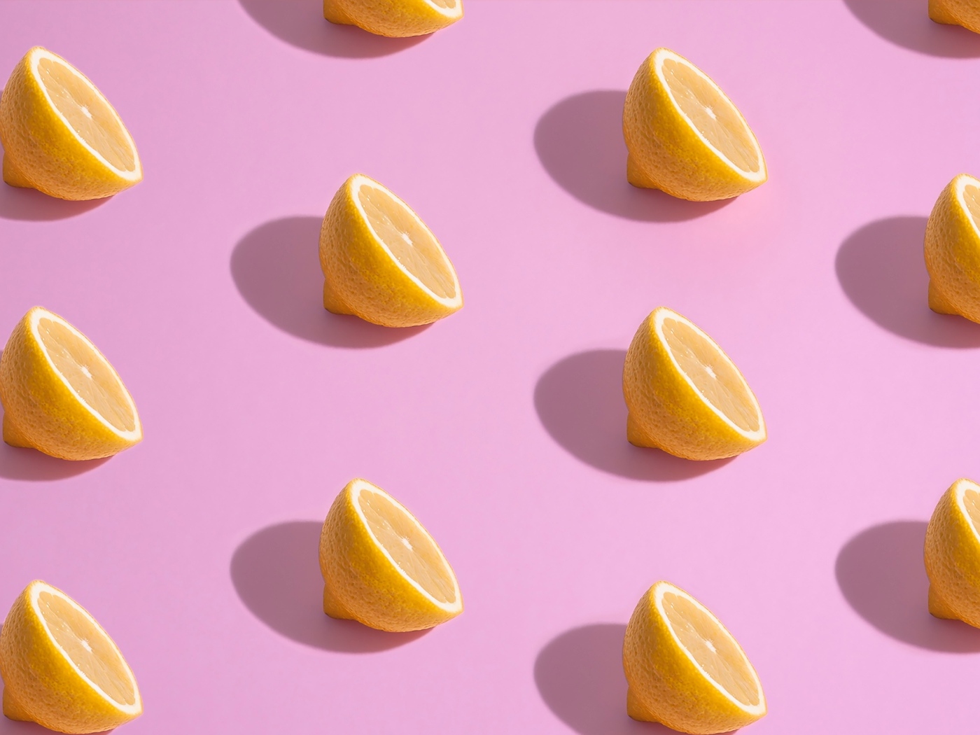 Половинки лимона на розовом фоне