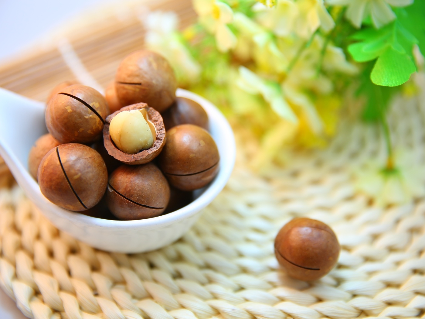 Орехи макадамия на столе с цветами