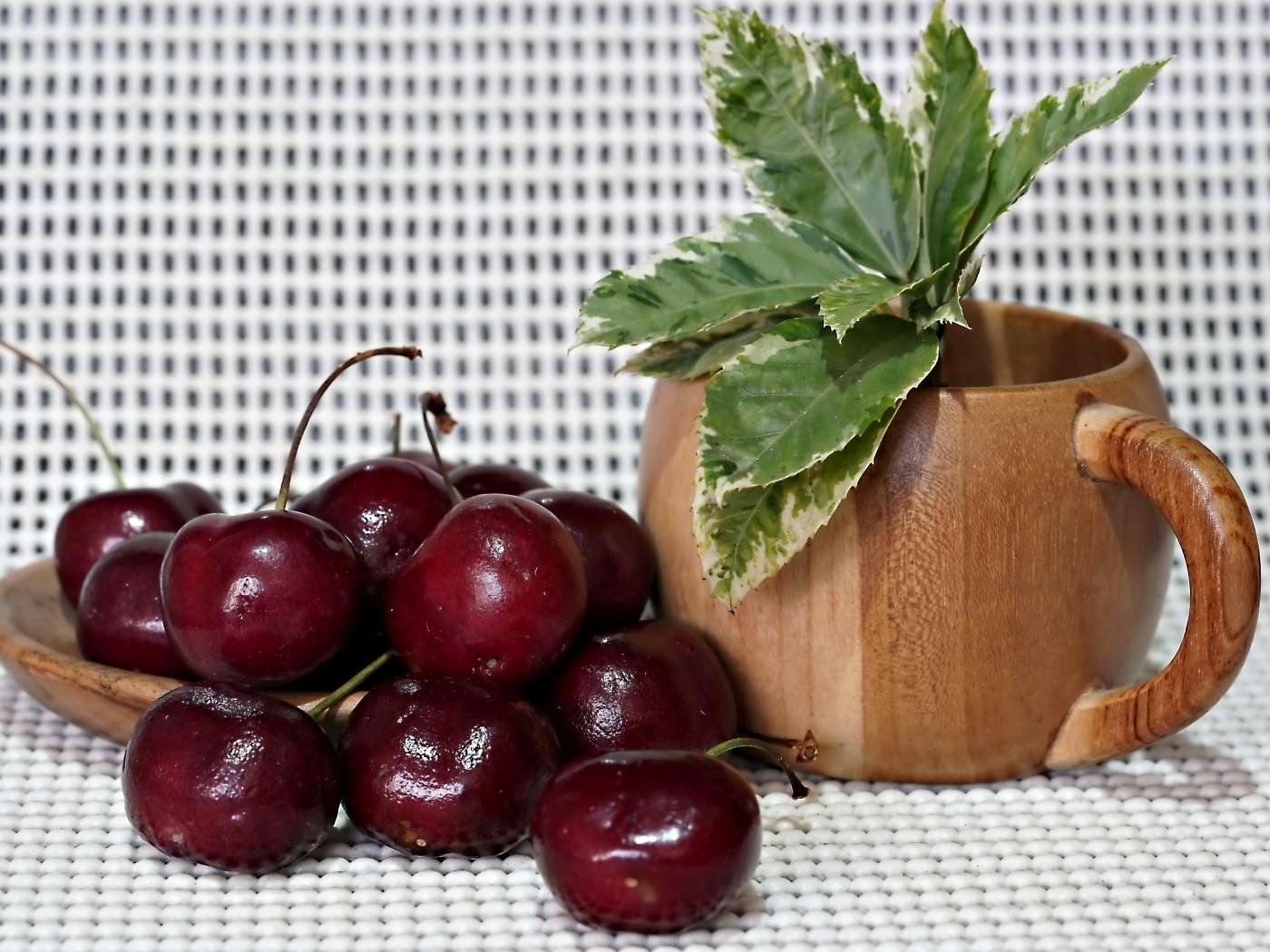 Спелые красные черешни на столе с цветком