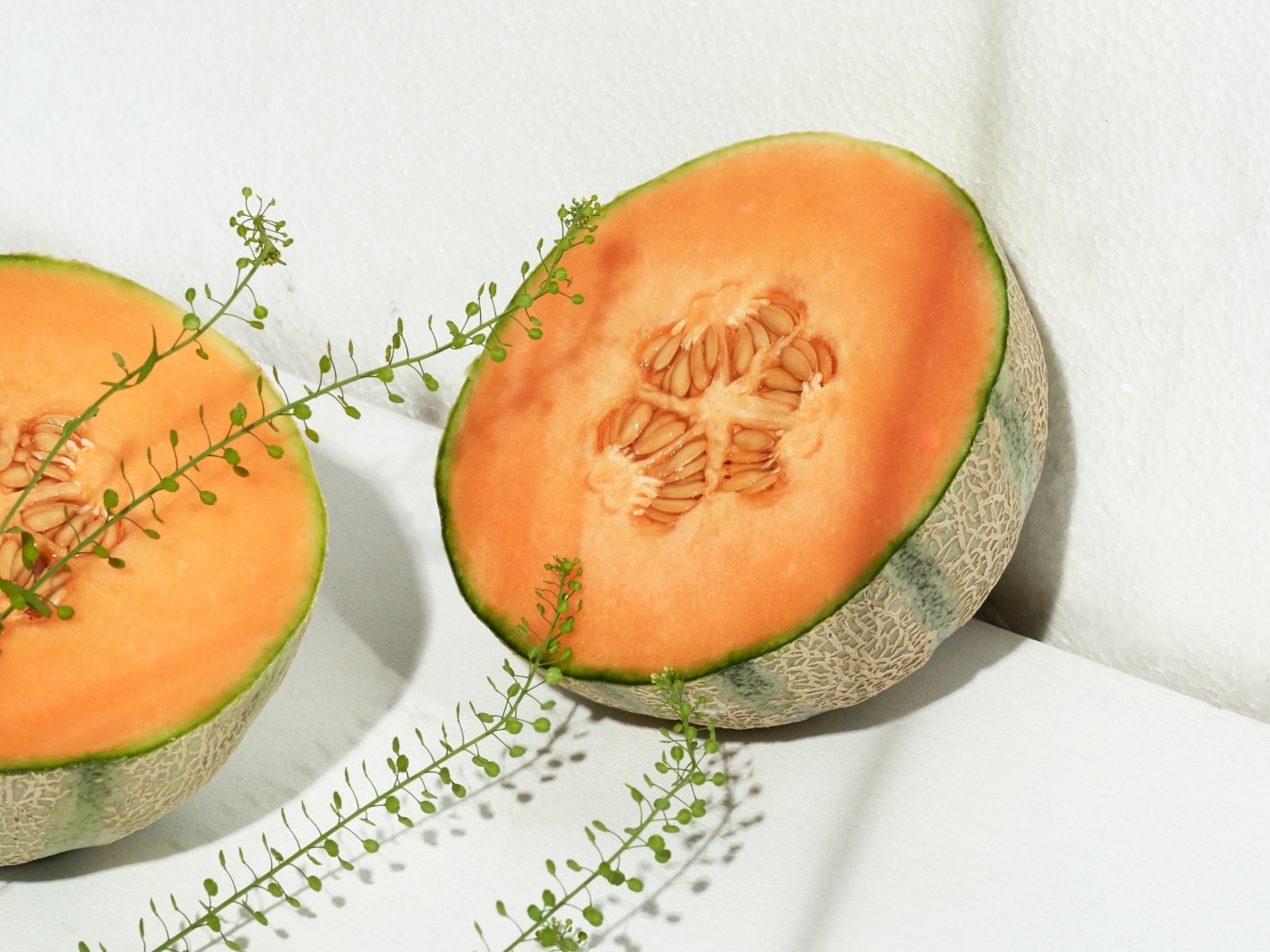 Две половины дыни с травой на белом диване