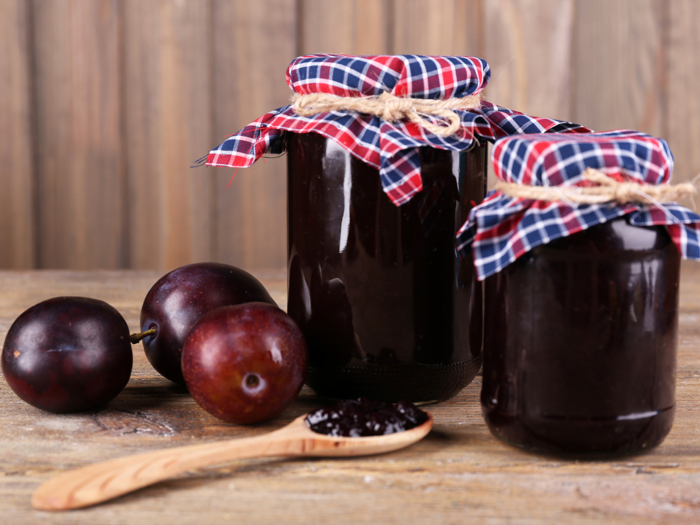 Две банки джема на столе со сливами