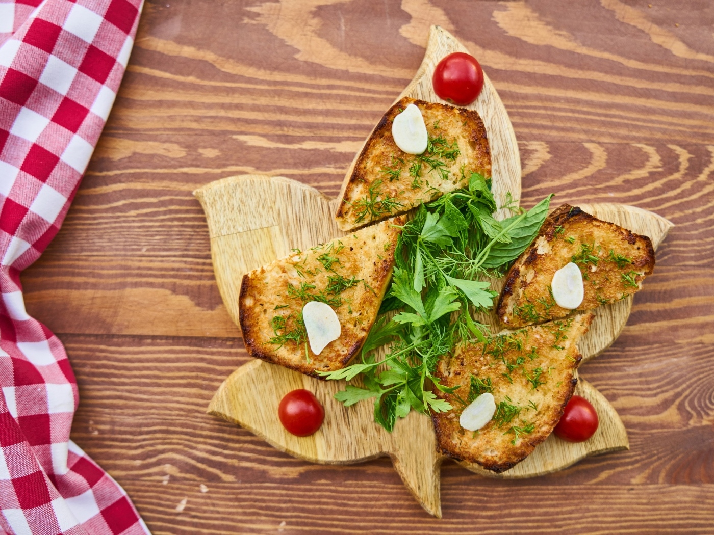 Жареный хлеб на доске с зеленью и помидорами