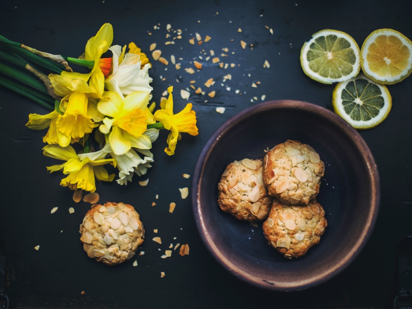 Печенье на столе с лимоном и букетом нарциссов