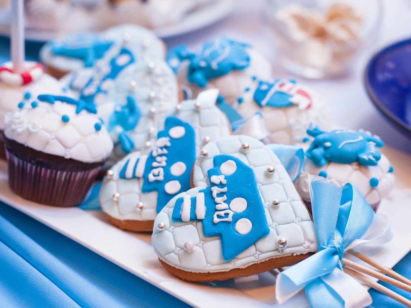 Пряники в форме сердца на палочке с кексами на столе