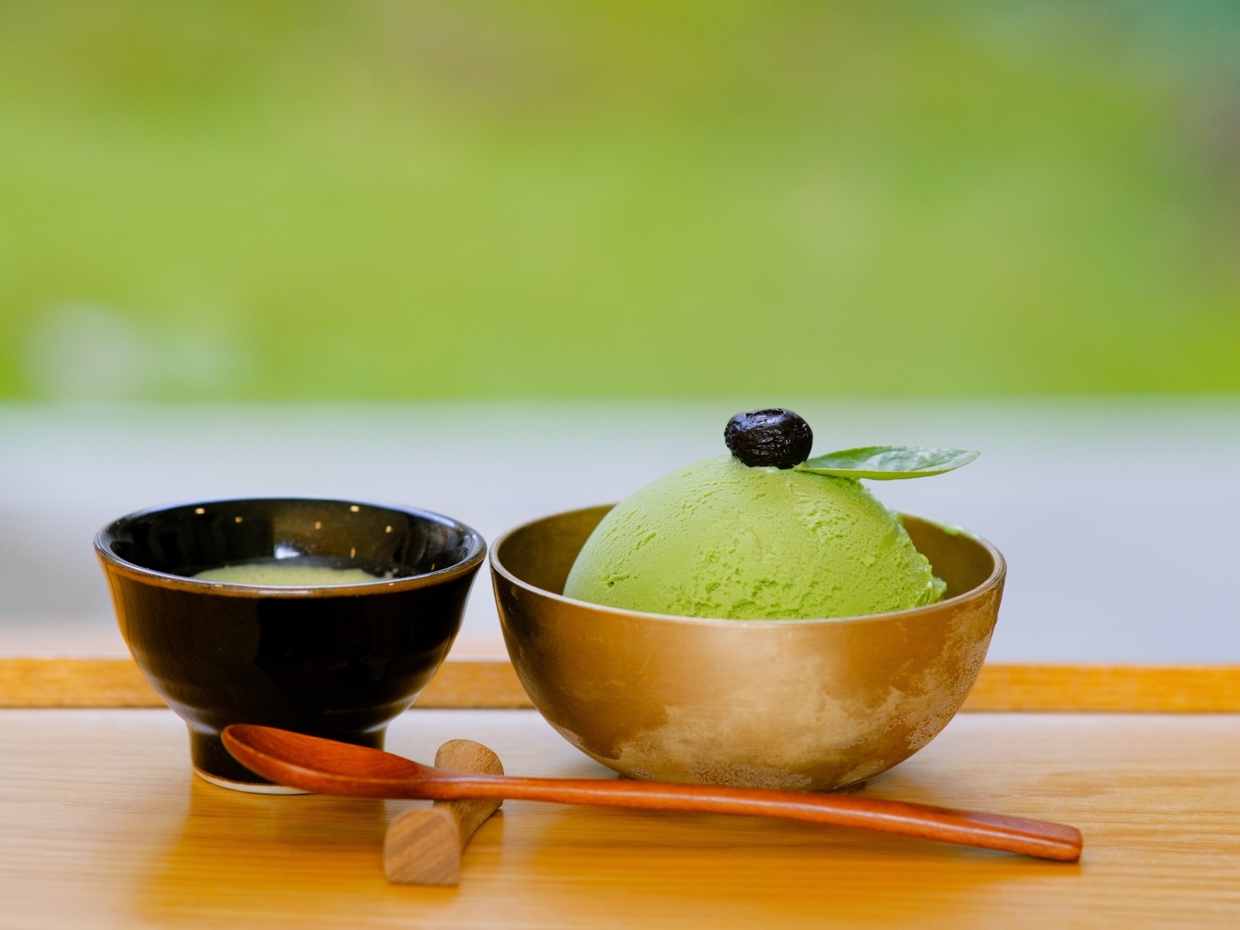 Зеленый шарик мороженого в чашке на столе