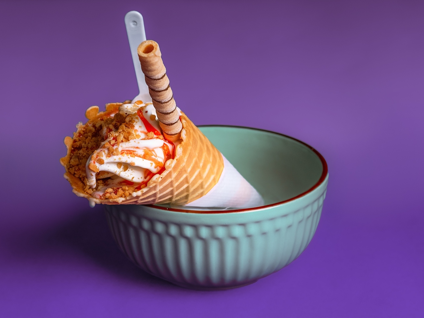 Мороженое рожок с трубочкой на фиолетовом фоне