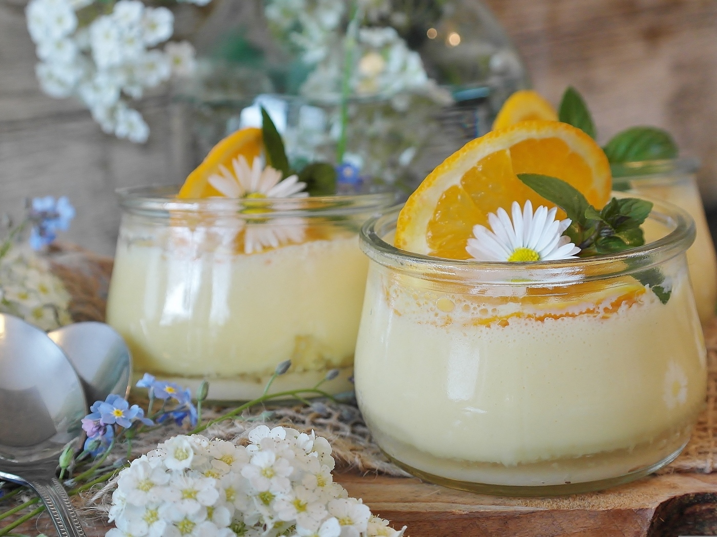 Лимонный крем в стеклянных банках на столе с цветами