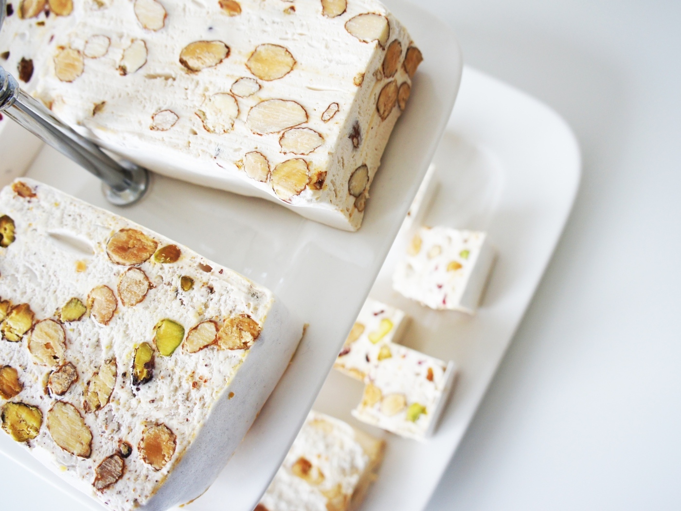 Нуга с орехами на белой тарелке