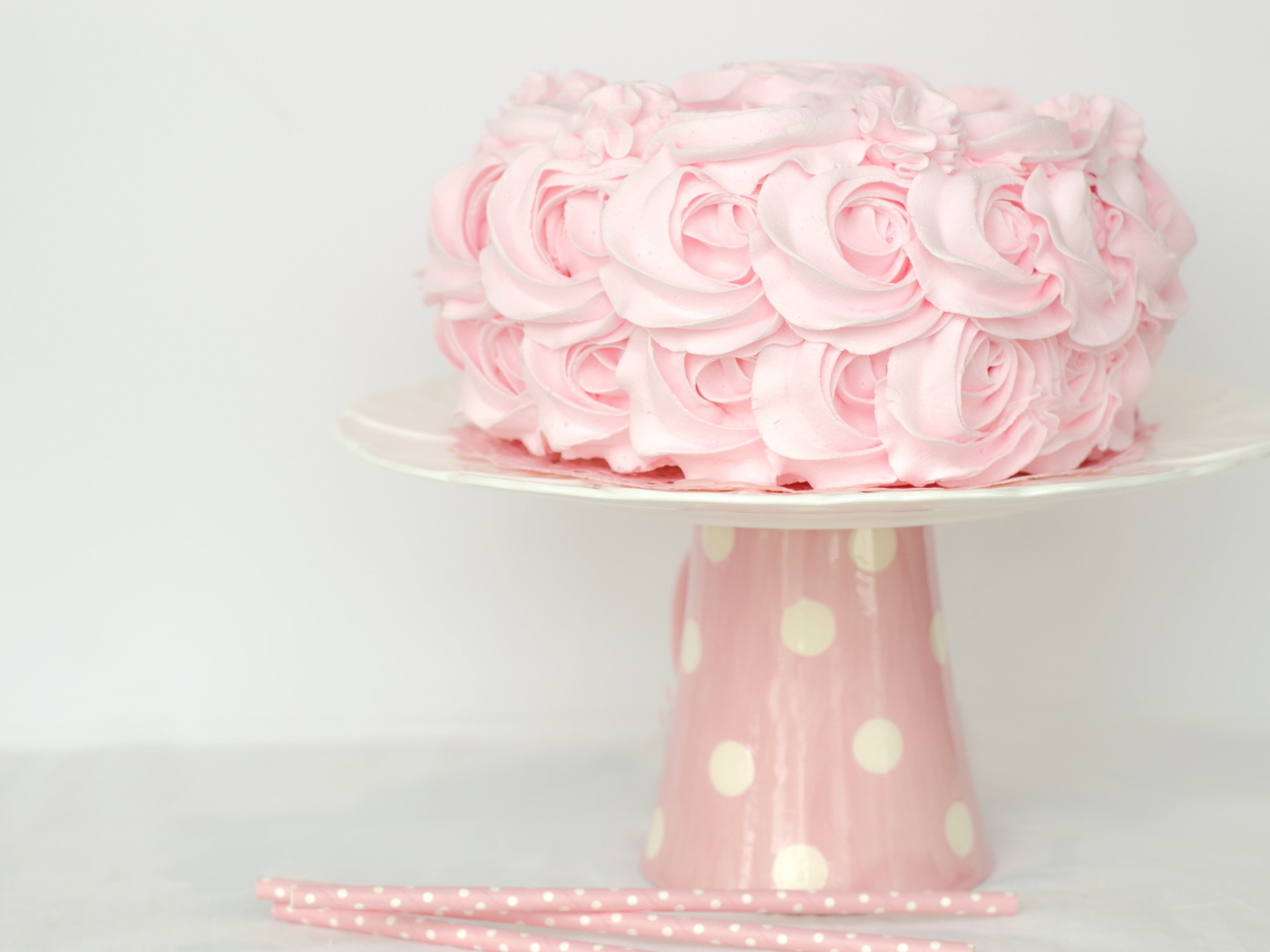 Розовый праздничный торт на столе