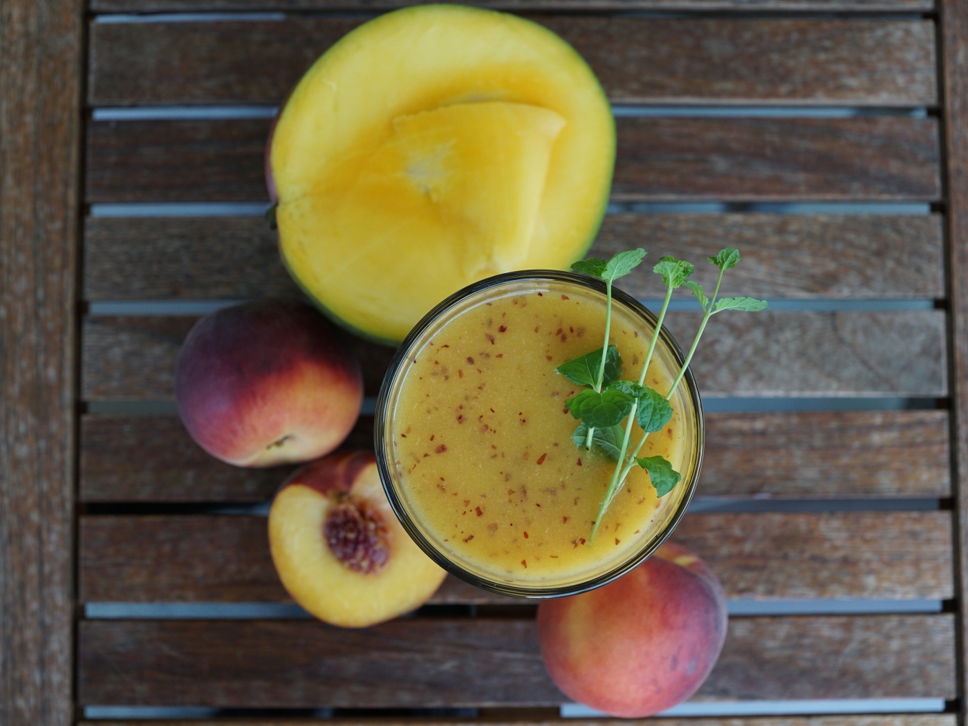 Коктейль с веточкой мяты на столе с фруктами