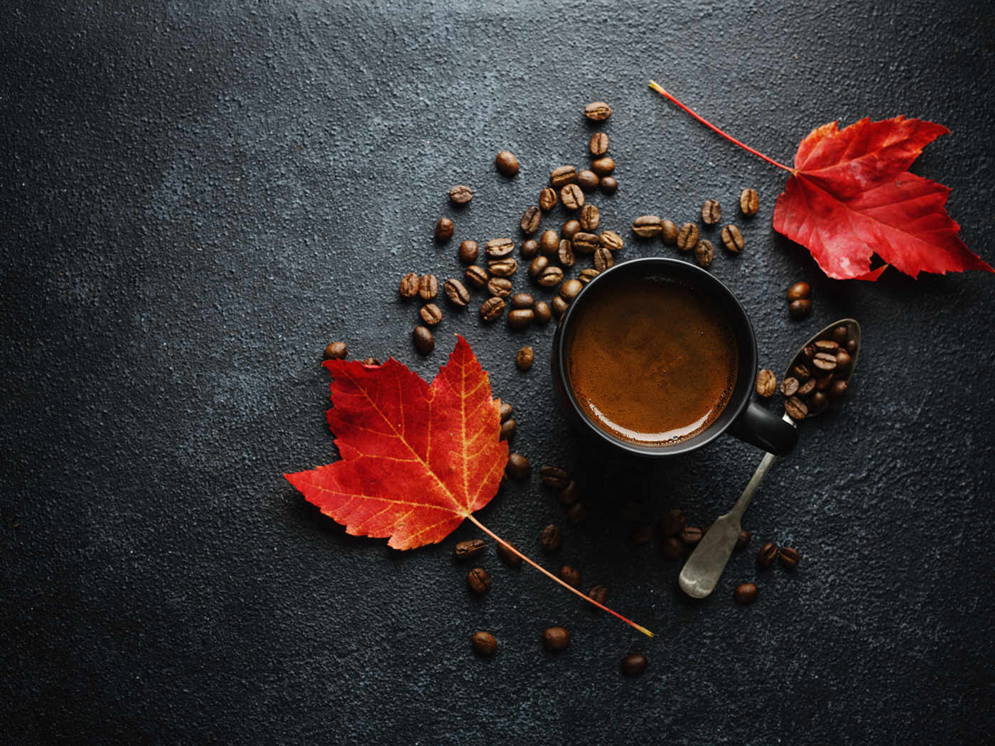 Чашка кофе на столе с зернами и желтыми листьями