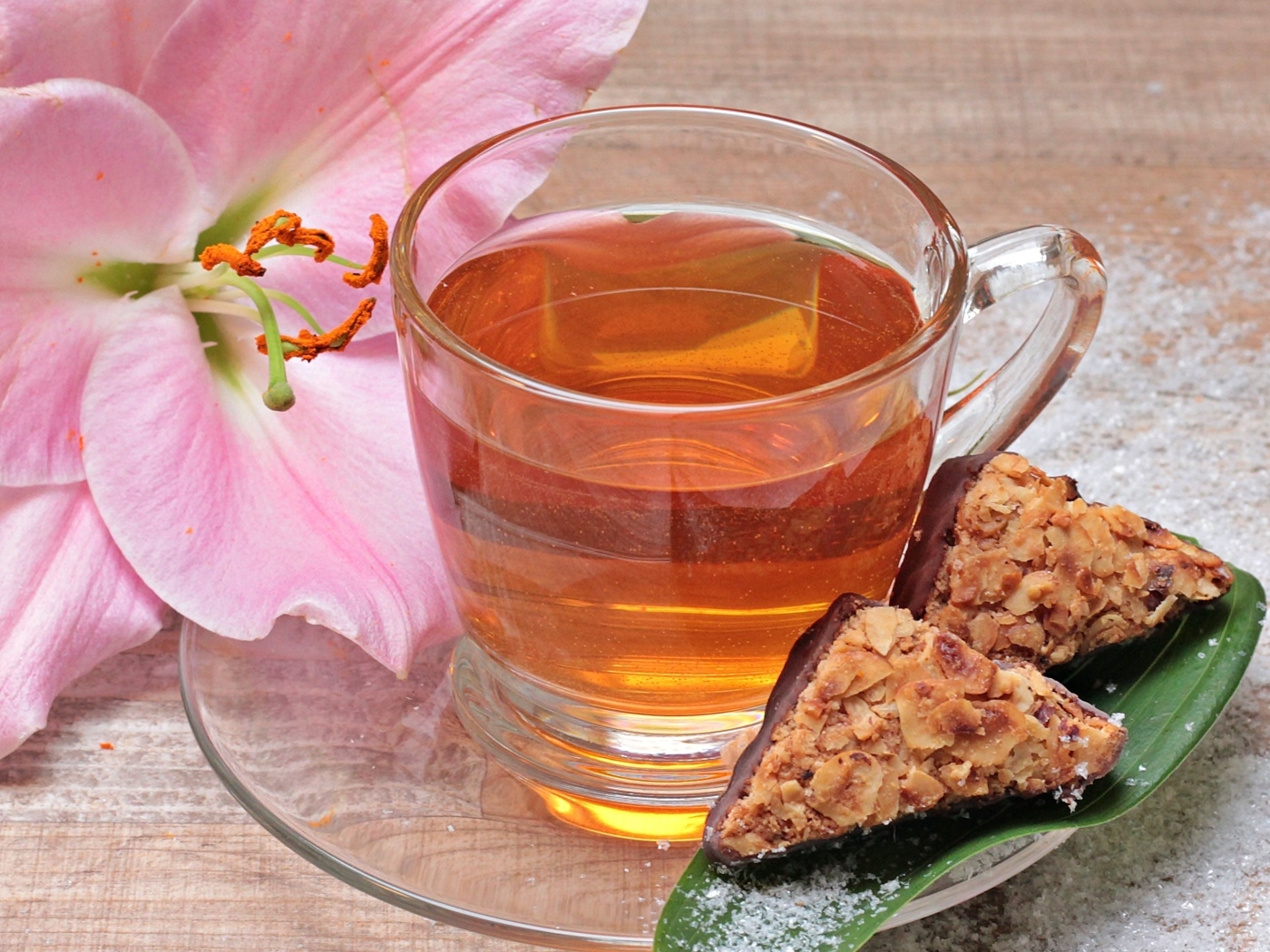 Чай на столе с розовой лилией и конфетами