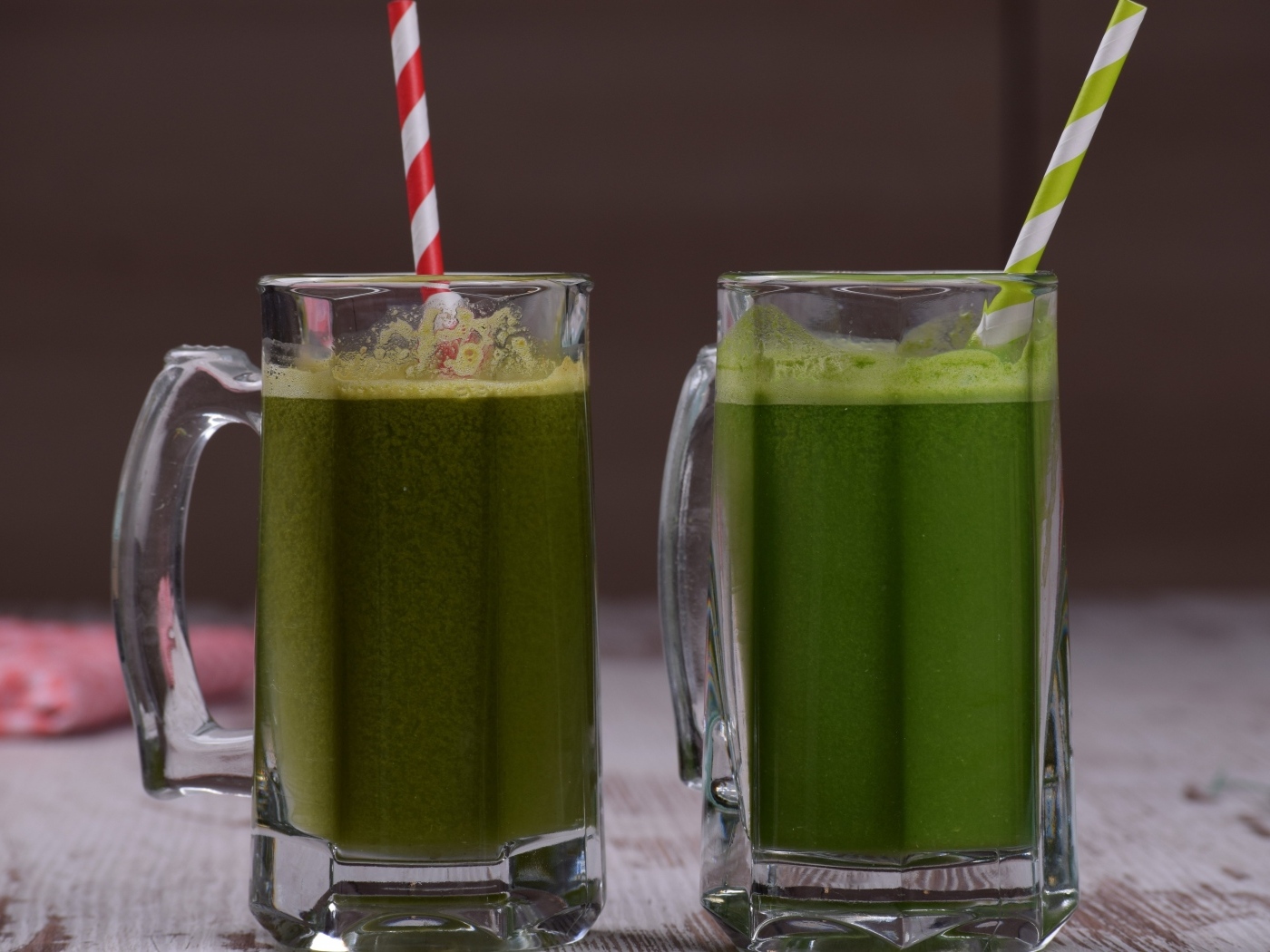 Два стакана зеленого смузи с трубочками