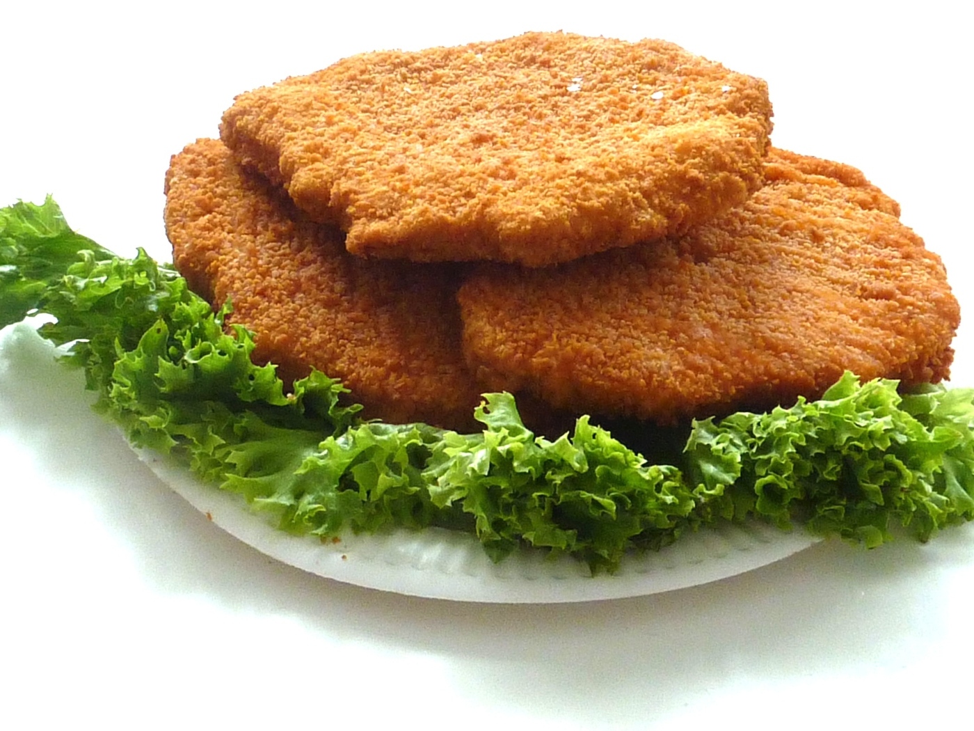 Куриные котлеты с листьями салата на тарелке