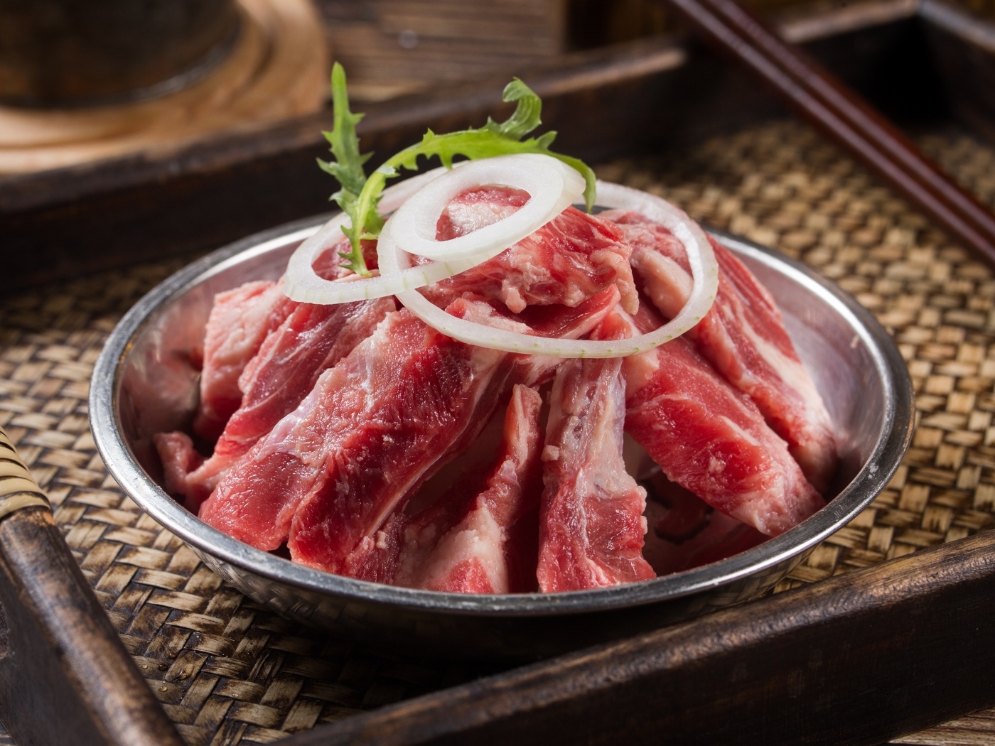 Свежие свиные ребра с луком в миске