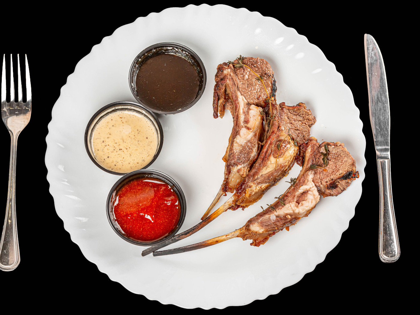 Свиные ребра с соусом на белой тарелке 