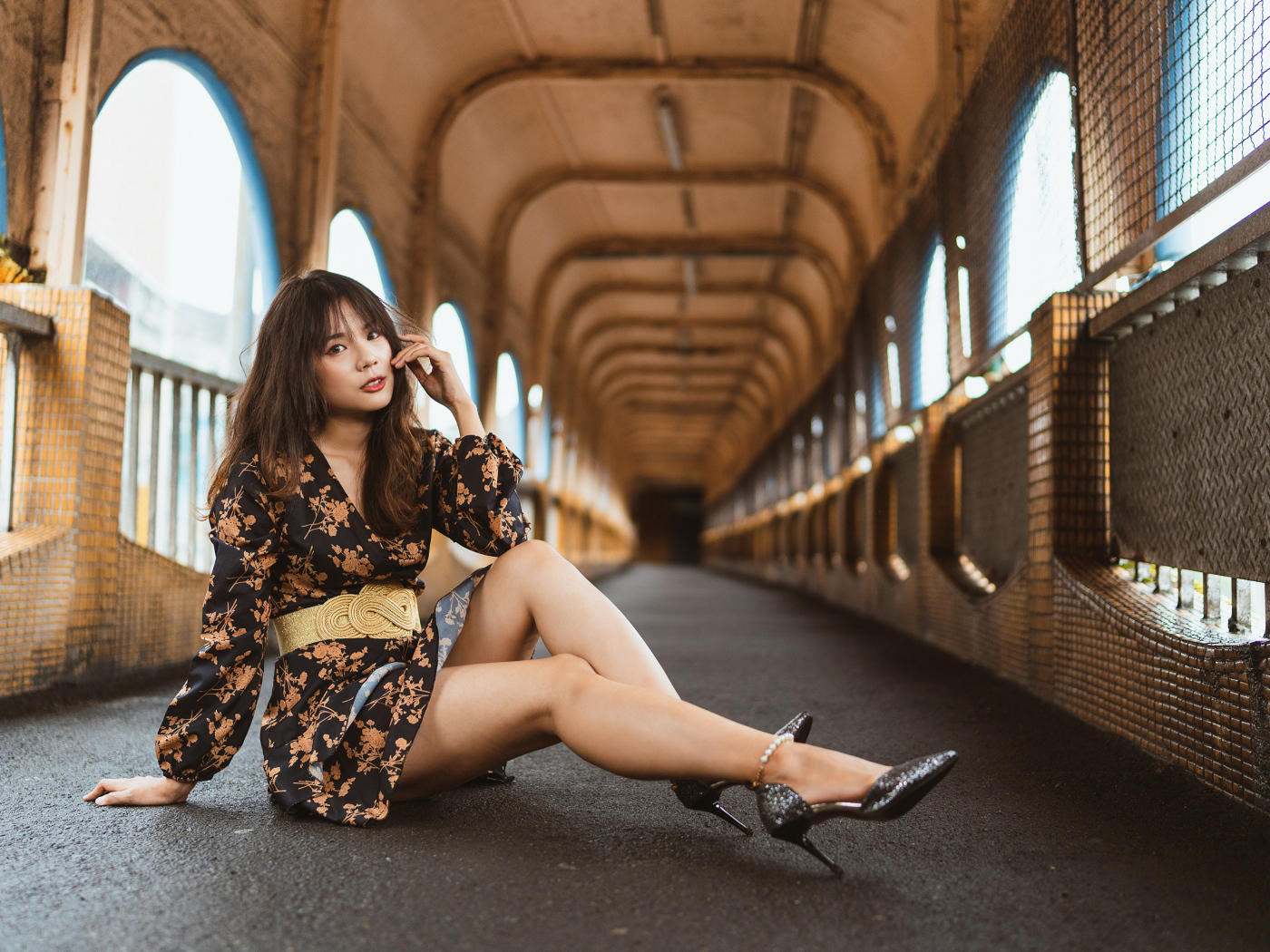 Девушка в красивом коротком платье сидит на полу