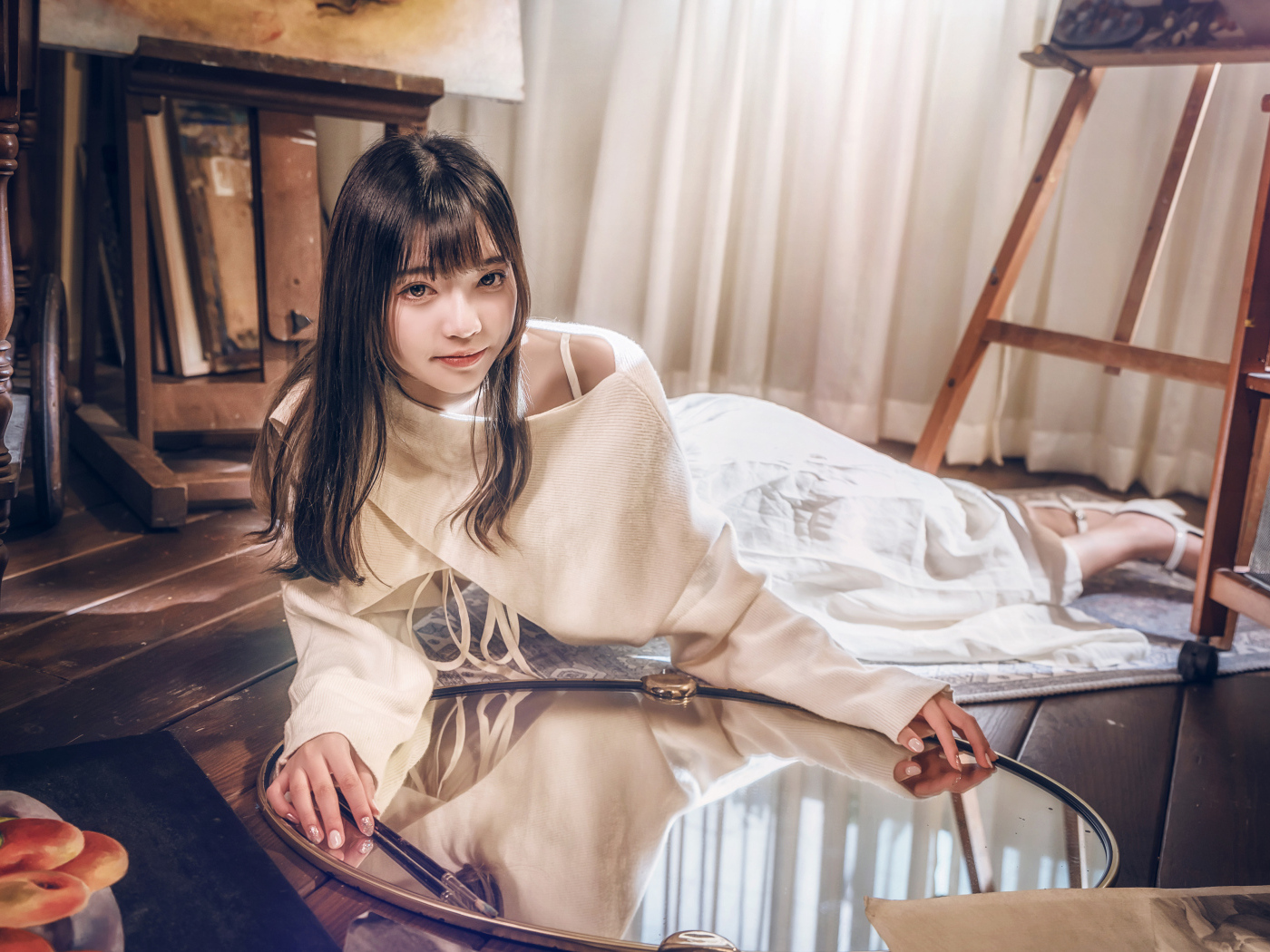 Девушка азиатка в белом платье лежит на полу