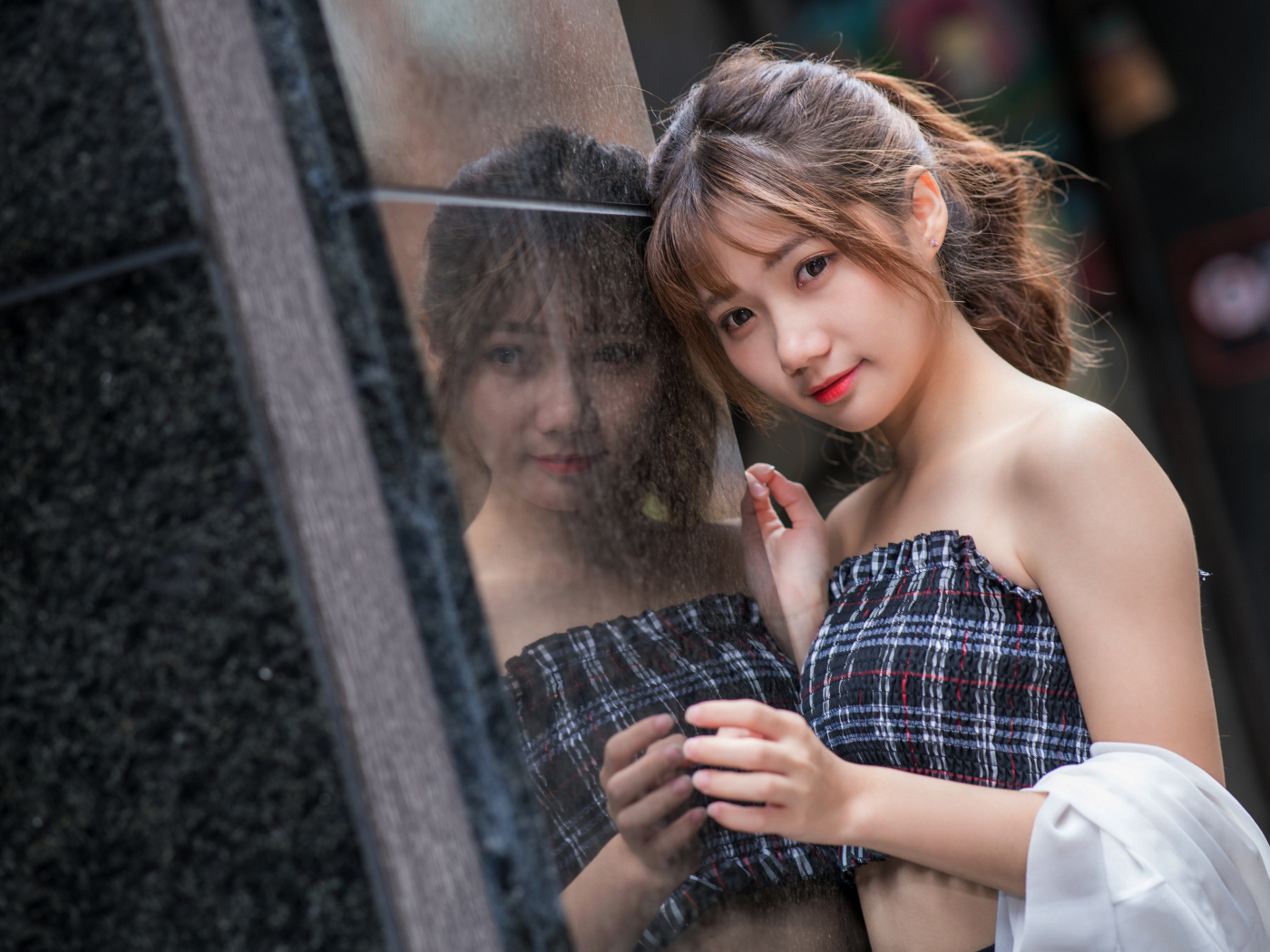 Девушка азиатка отражается в стене