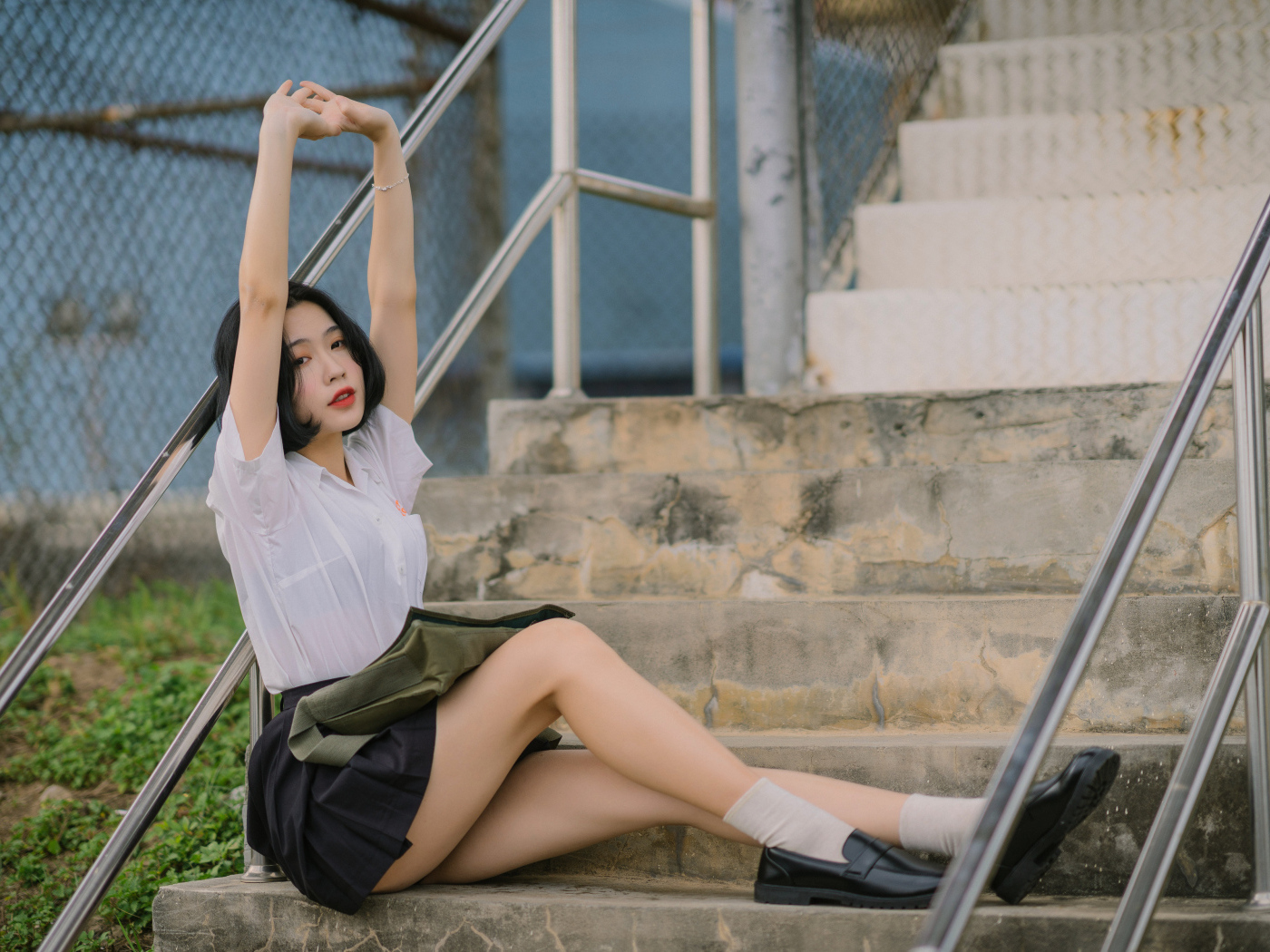 Девушка азиатка потягивается на ступеньках
