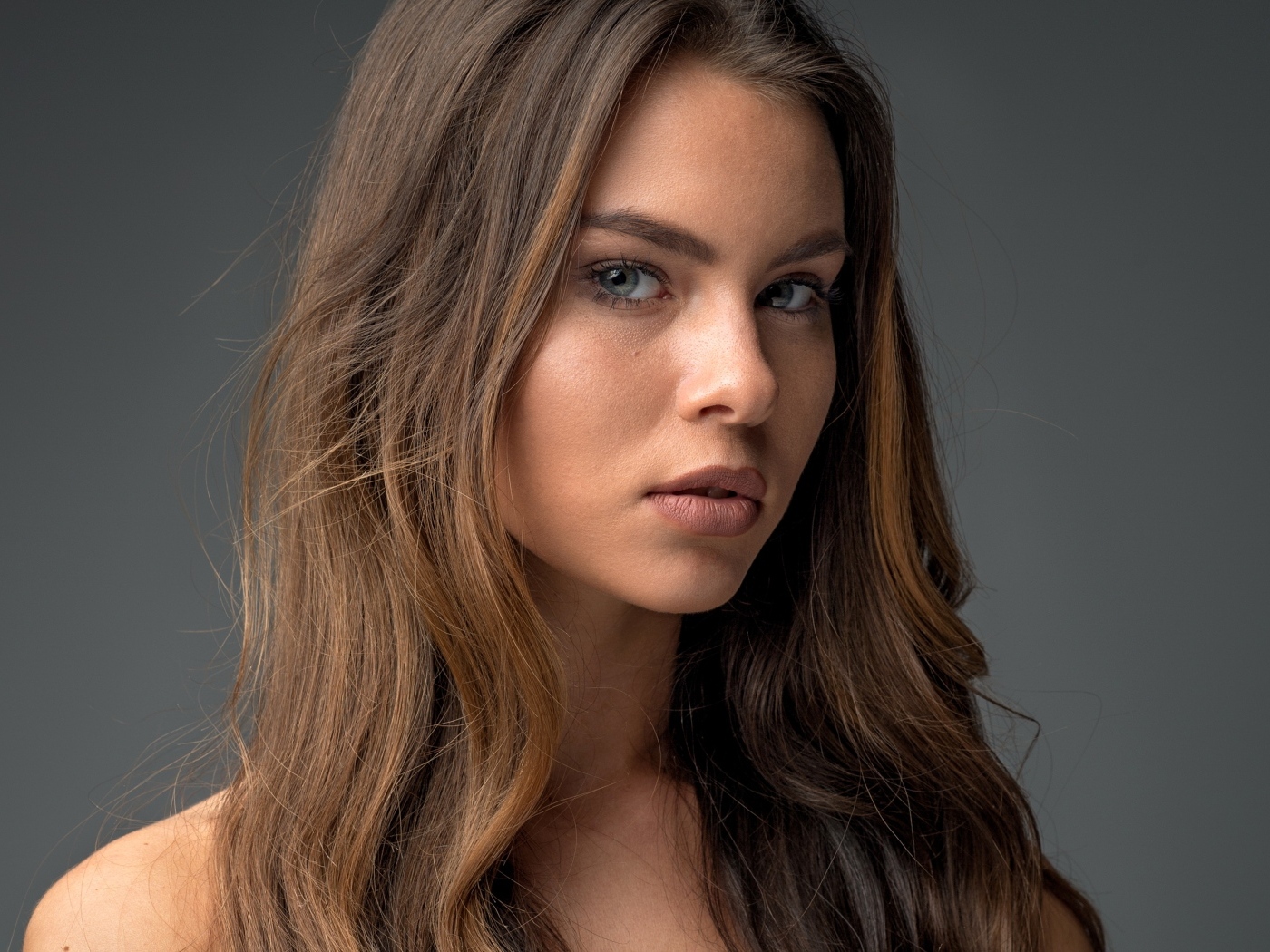 Красивая девушка шатенка на сером фоне 