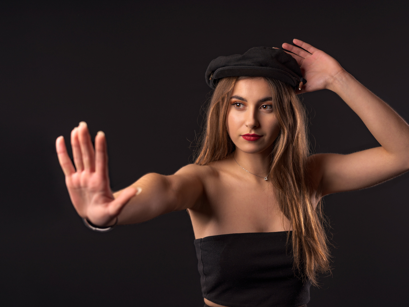Красивая девушка в кепке на черном фоне