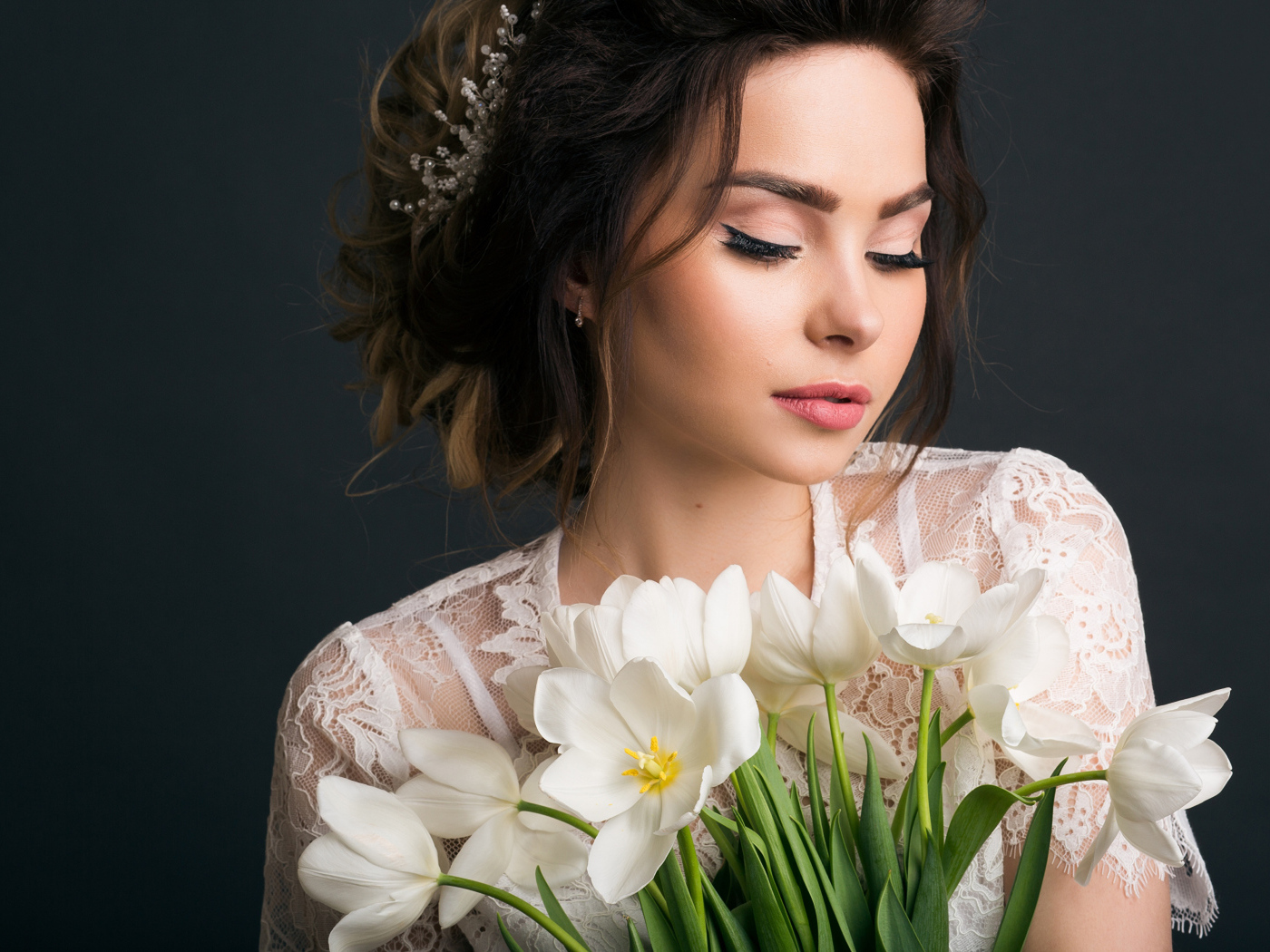 Красивая девушка с букетом белых тюльпанов на сером фоне