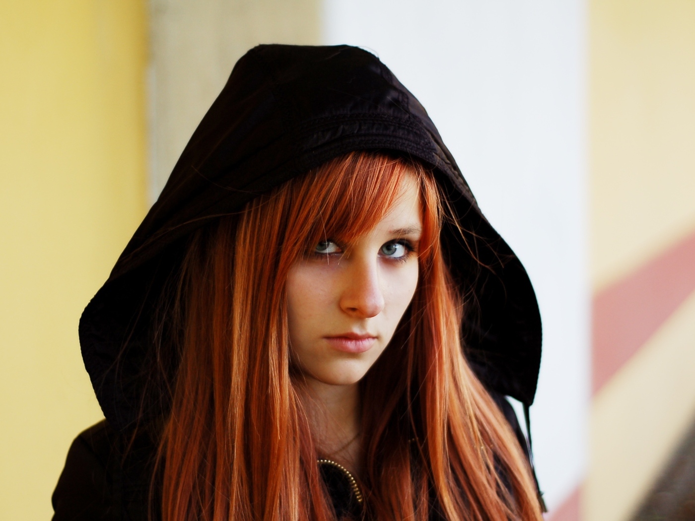 Красивая рыжеволосая девушка в черном балахоне