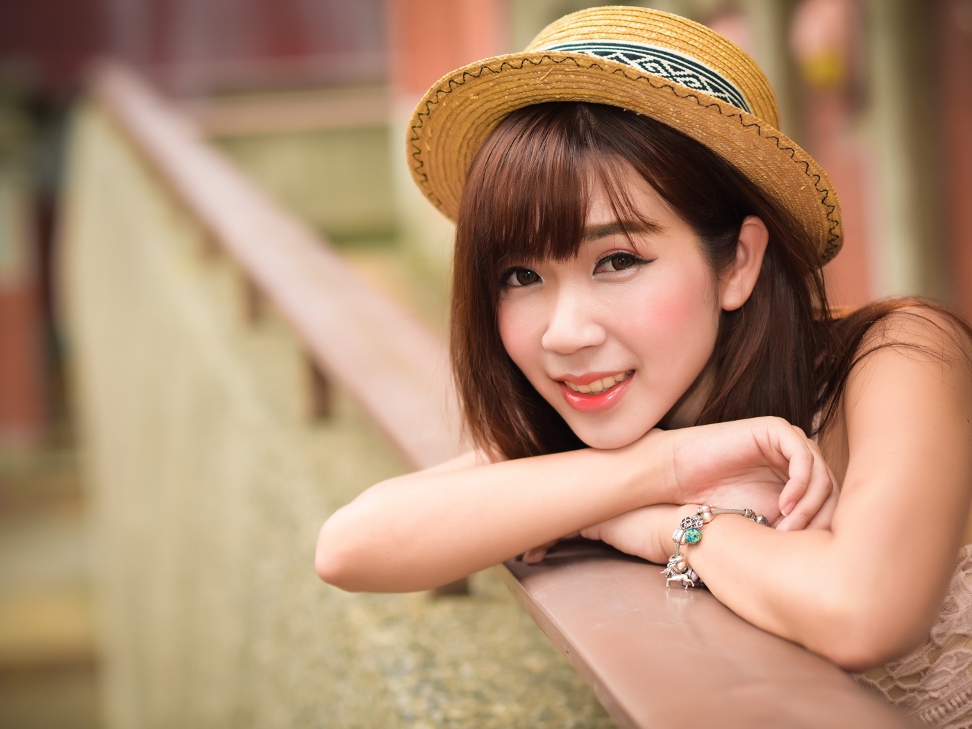 Милая улыбка азиатки в соломенной шляпе 