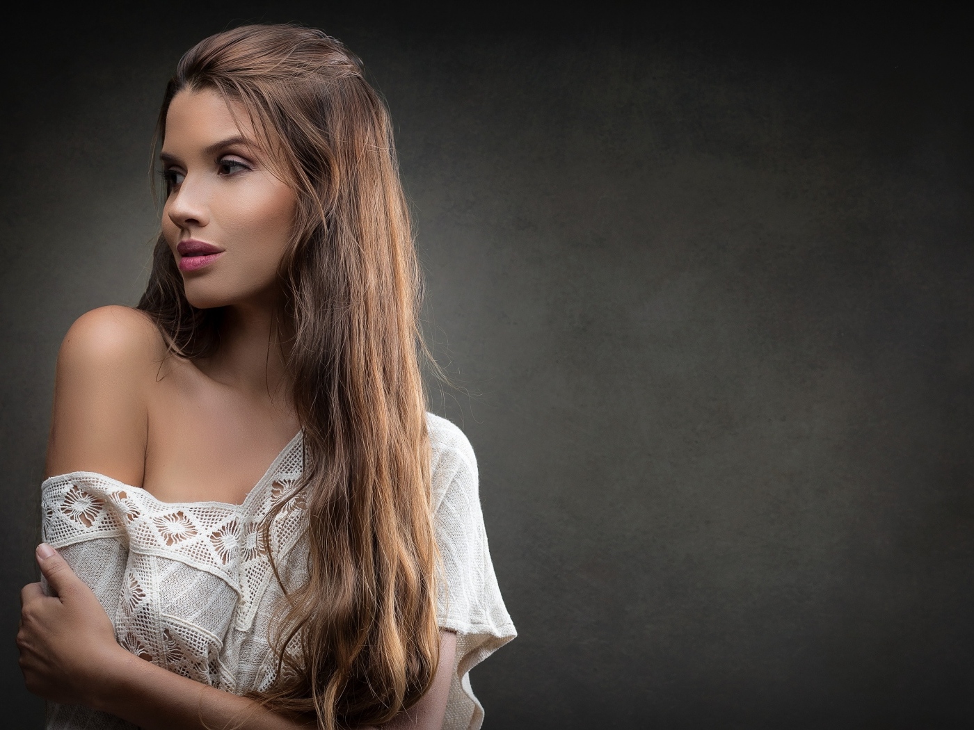 Девушка в белом платье с длинными волосами на сером фоне