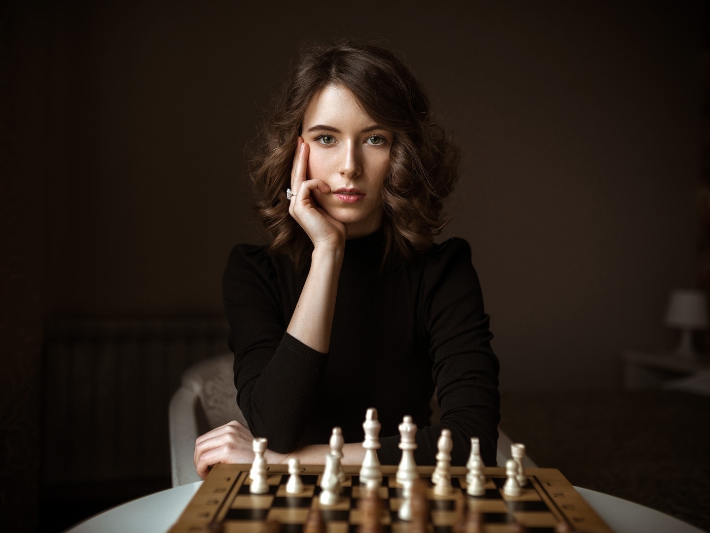 Умная молодая девушка играет в шахматы