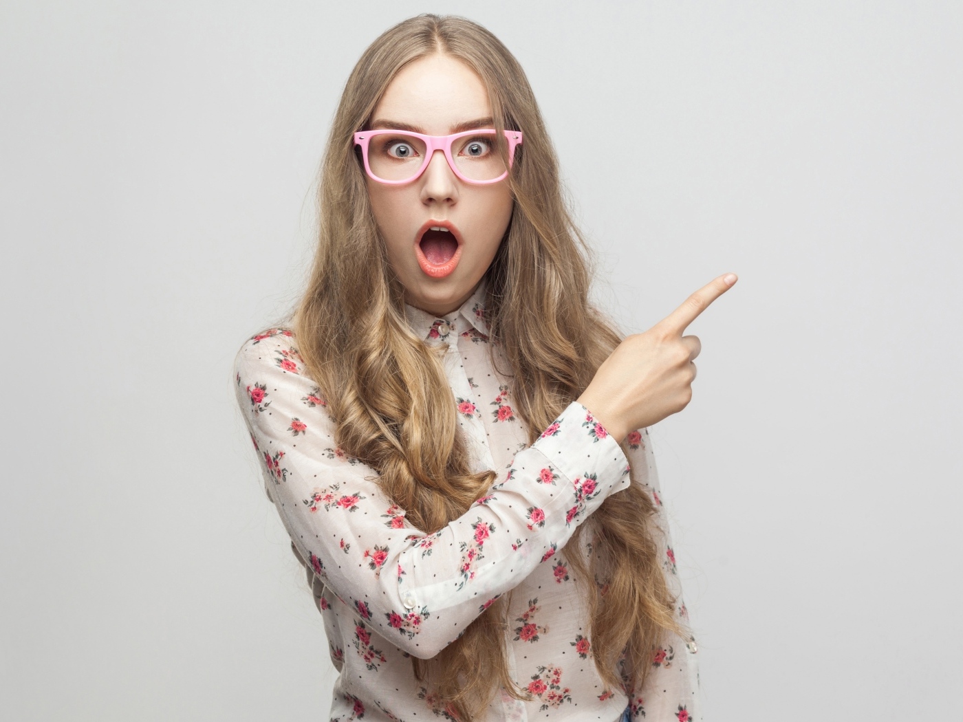 Удивленная девушка на сером фоне