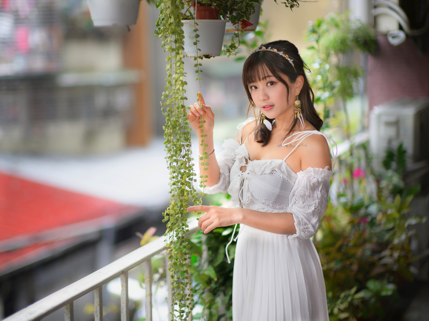 Молодая азиатка в белом платье у растений